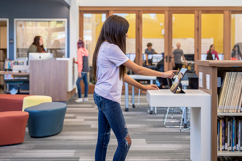 Interior photo of student using iPad inside Learning Resource Center