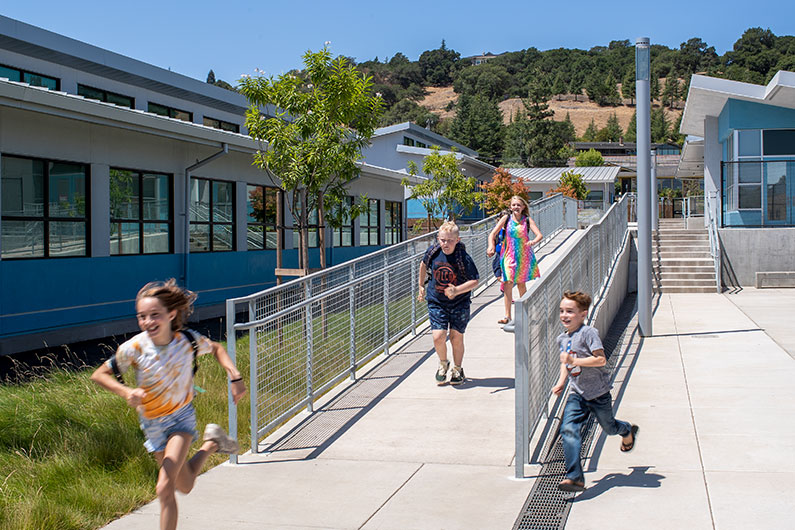 4 kids running down ramp at Irene Snow Elementary School