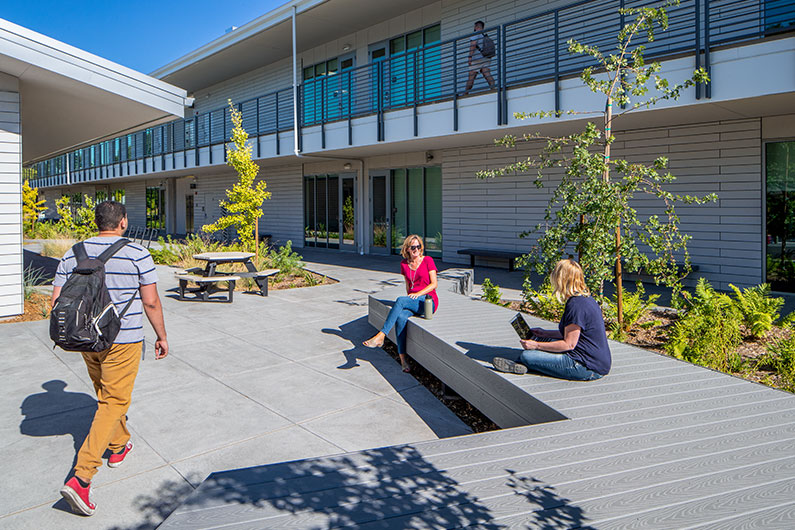 3 people relaxing outdoors at Jeff Kunde Hall Courtyard