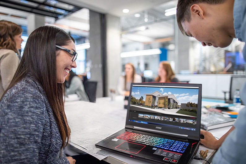 Chelsea Hamada working on laptop with designer in office