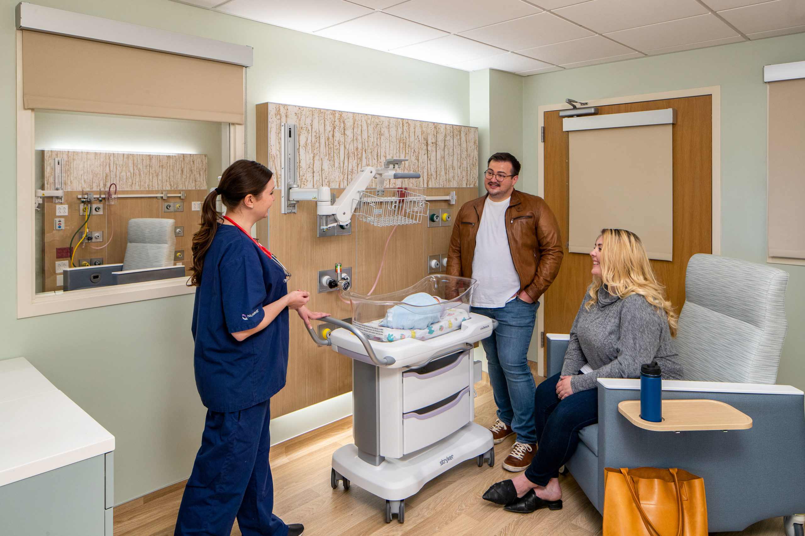 Doctor talking to parents in exam room at Kaiser Permanent Neonatal Intensive Care Unit