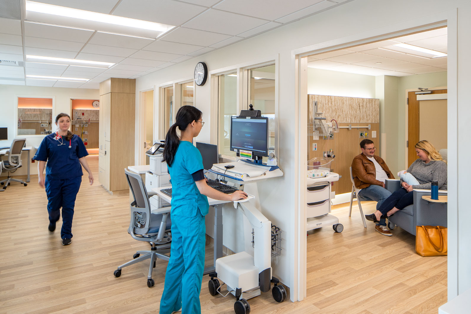 Two nurses and parents in Neonatal Intensive Care Unit