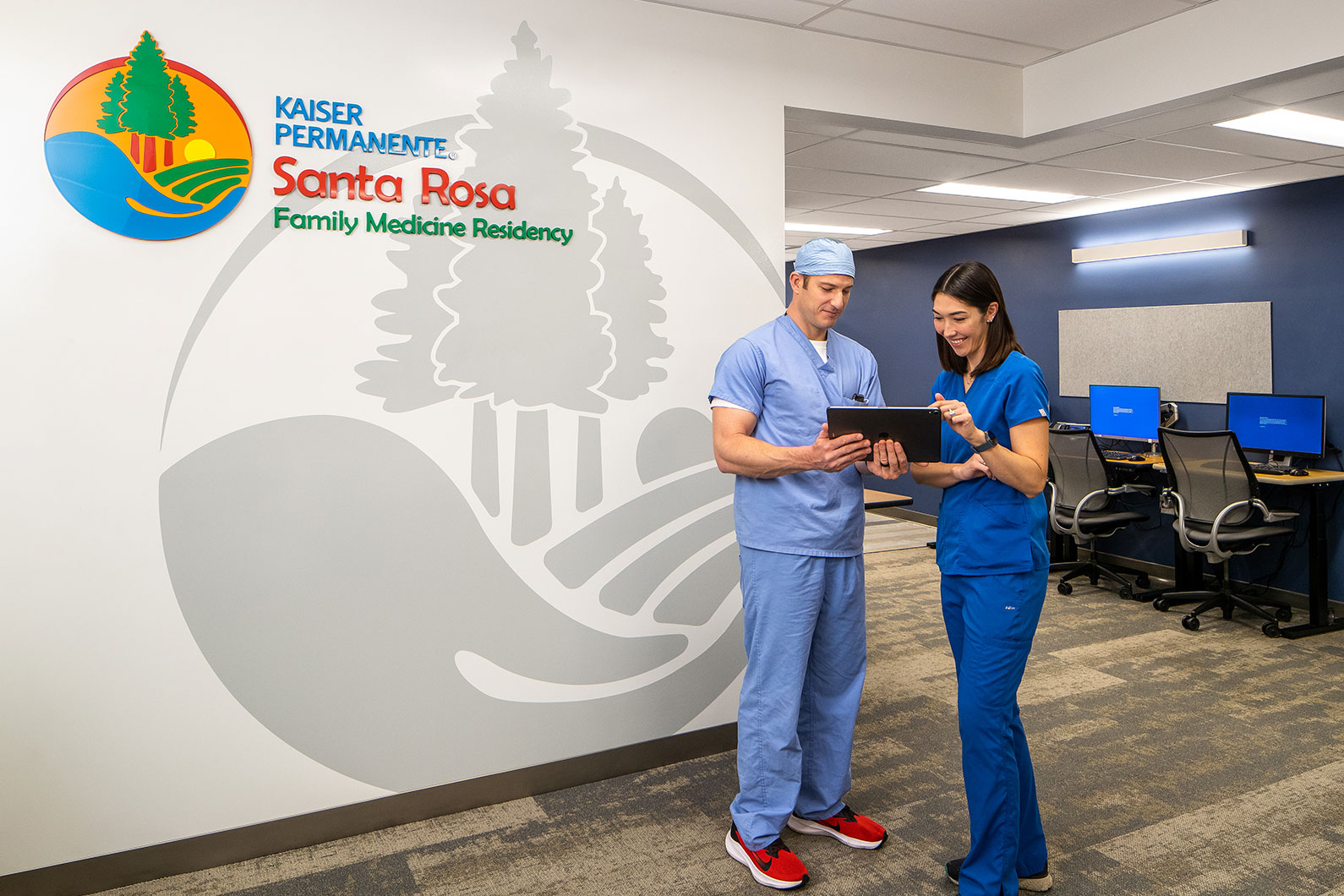 Two doctors standing next to Kaiser Permanente Santa Rosa Family Medicine Residency sign