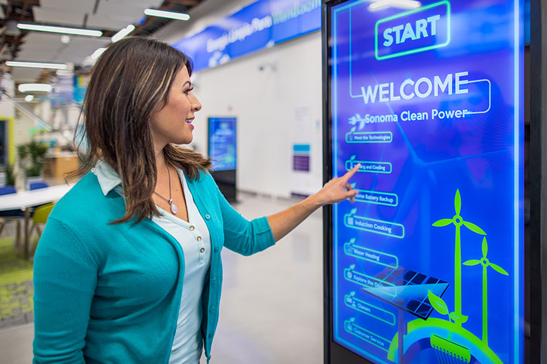 Woman using touch screen kiosk at Advanced Energy Center