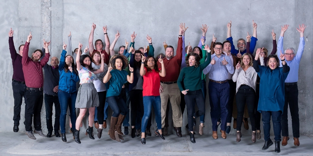 TLCD Staff shown jumping up in the air against a concrete background