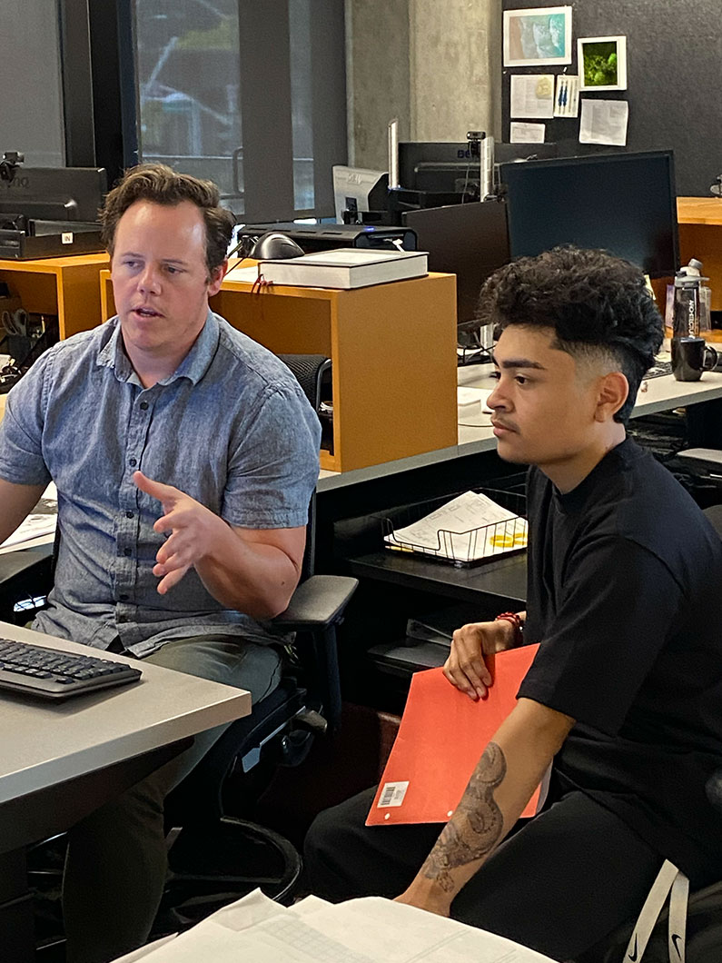 Summer intern meeting with architect at desk