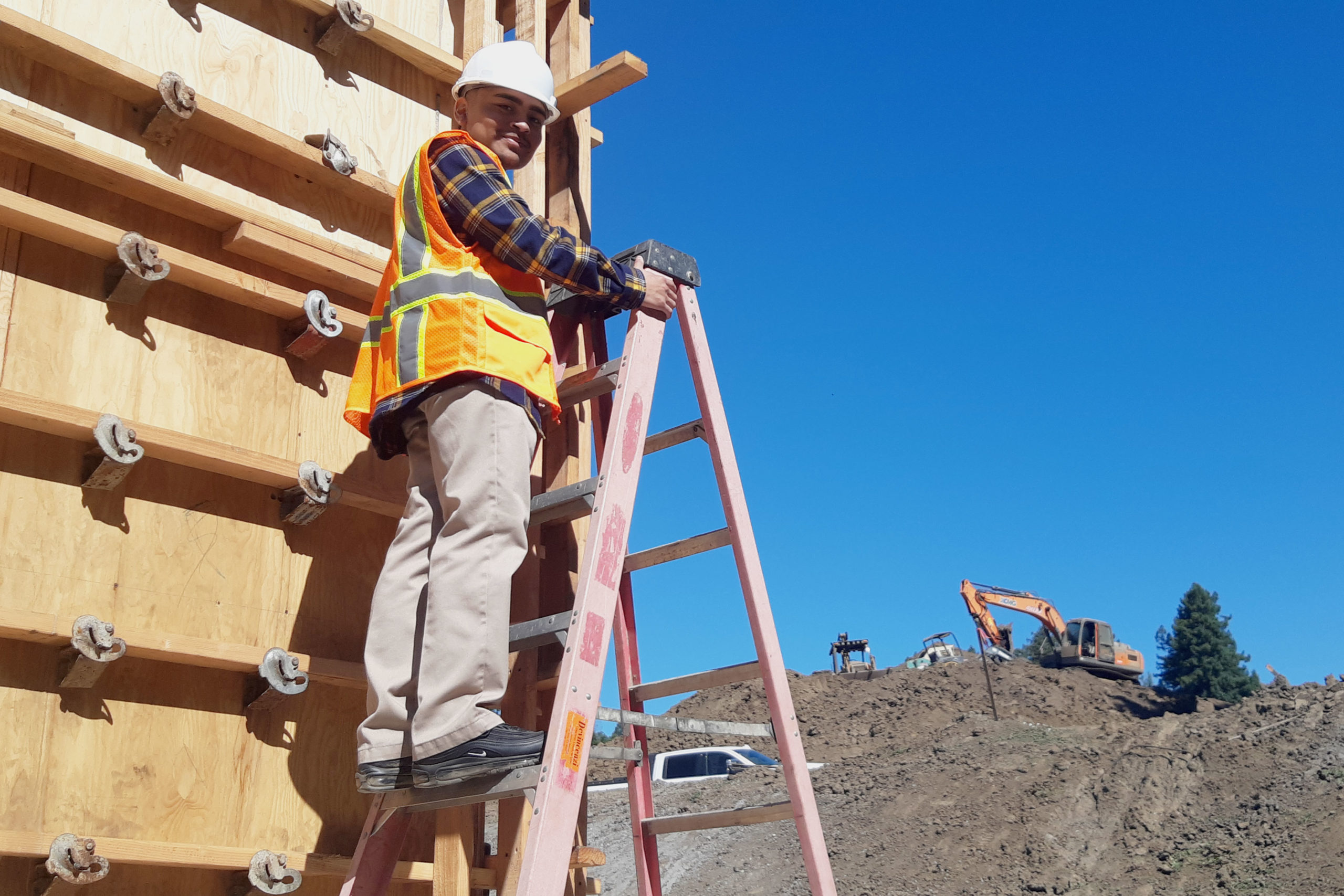 Ismael Carreno Ortiz on ladder at site visit with TLCD Architecture