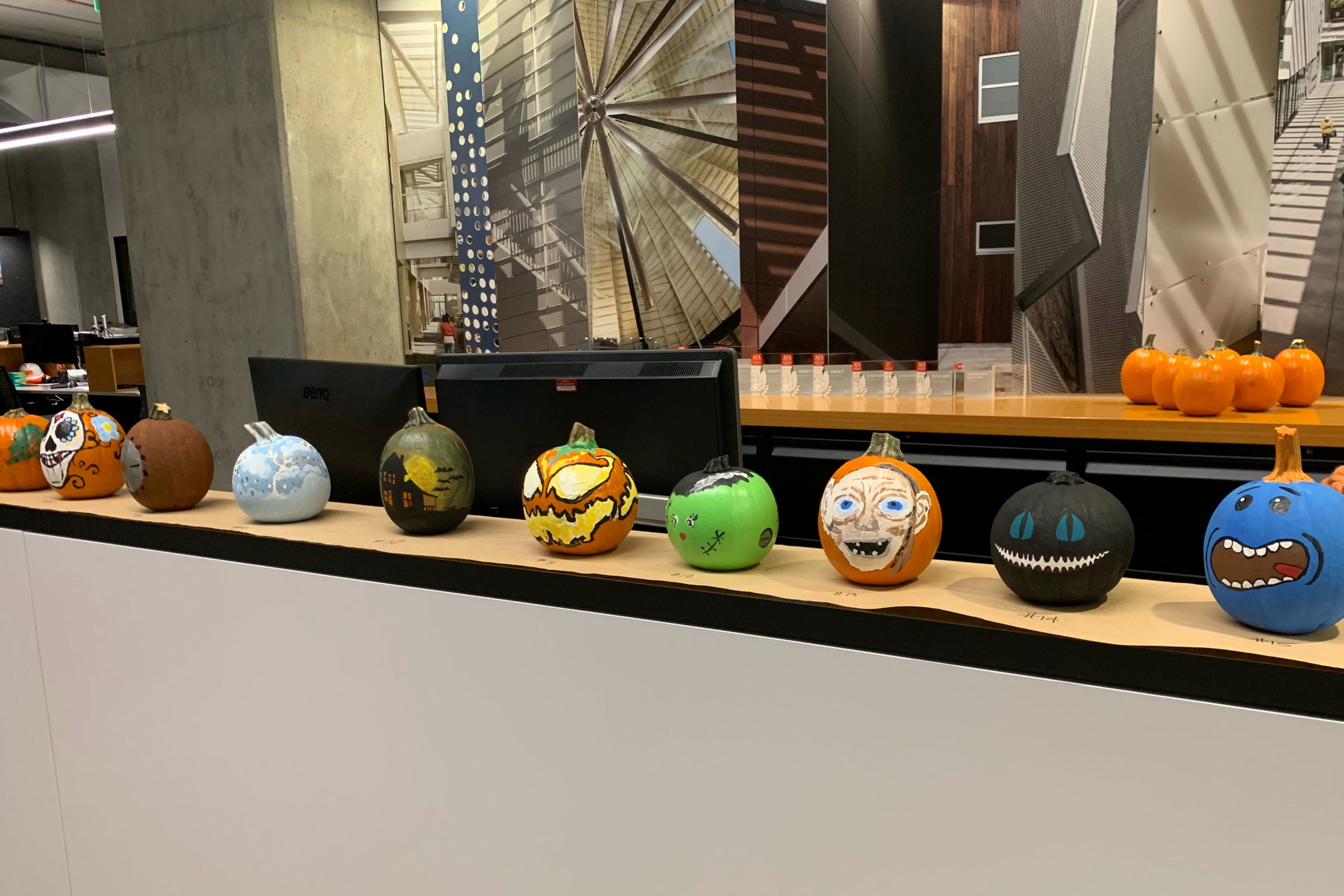 Colorful hand painted pumpkins lined up on counter at TLCD office