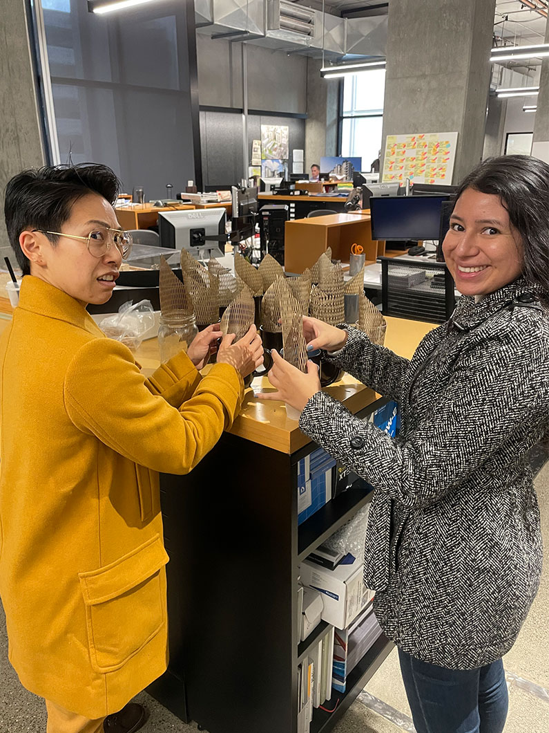 two women working on laser cut shapes at office