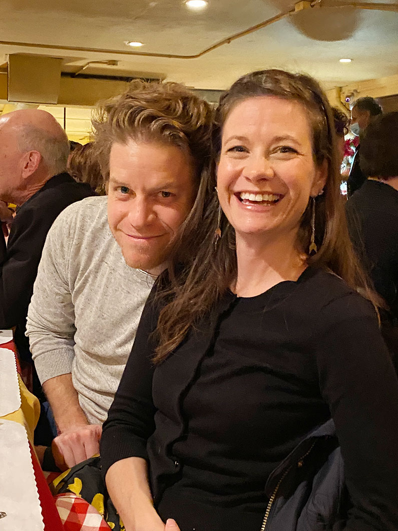 Smiling woman and man seated at holiday party