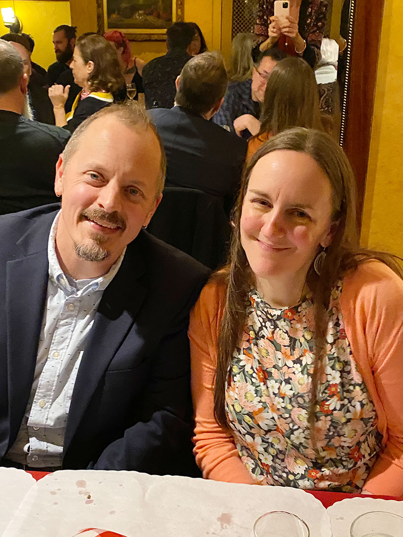 Couple seated and smiling at TLCD holiday party