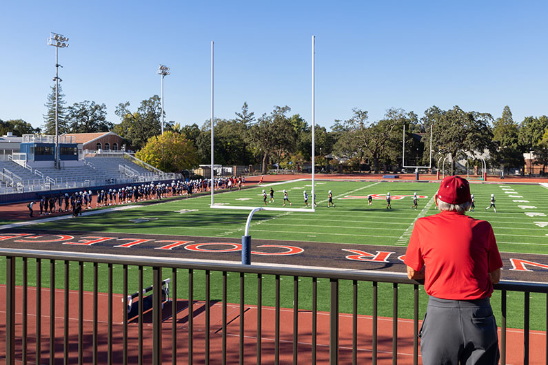 Man looking at football field from second story of SRJC field house