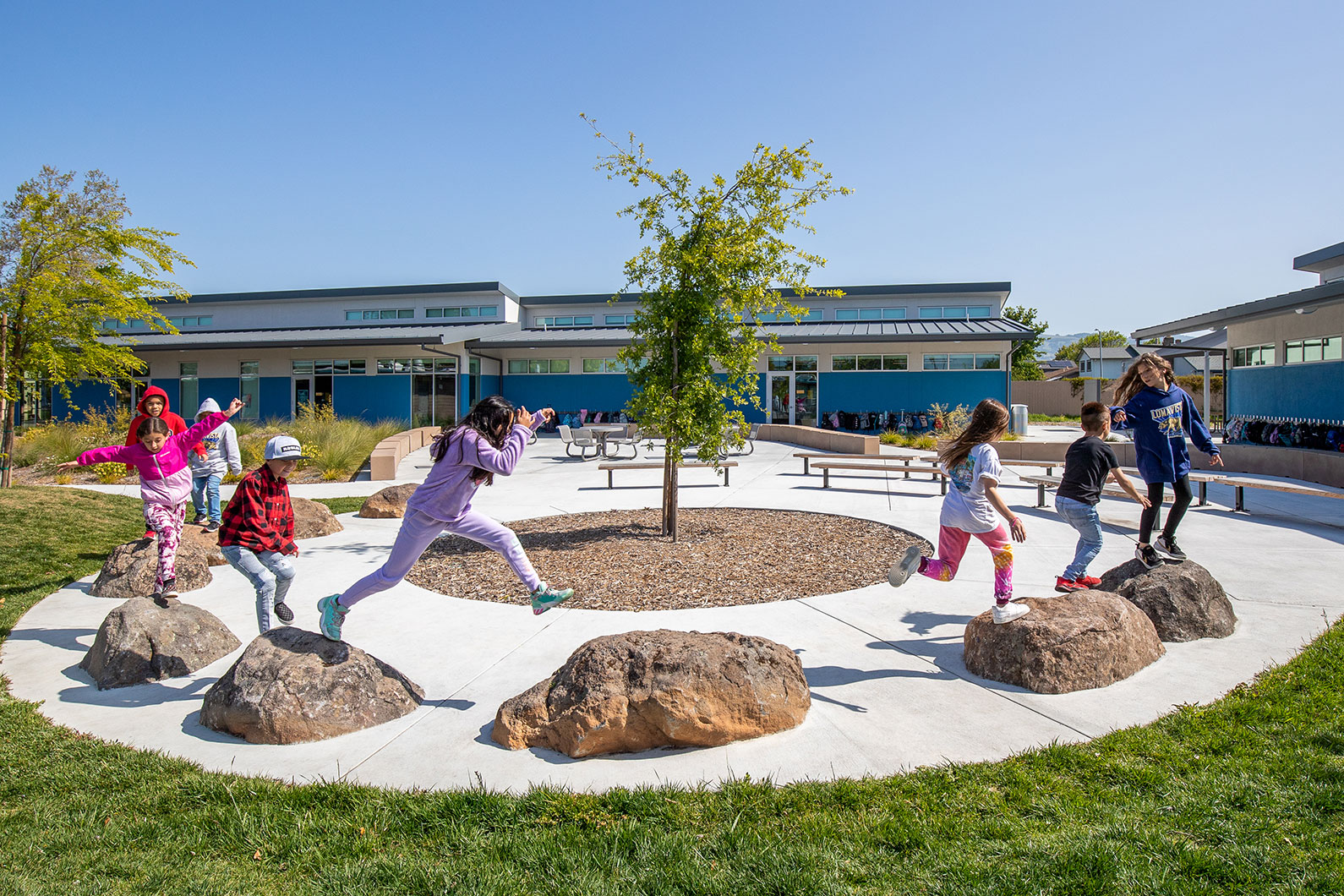 Kids jumping across rocks on playground at Loma Vista Immersion Academy