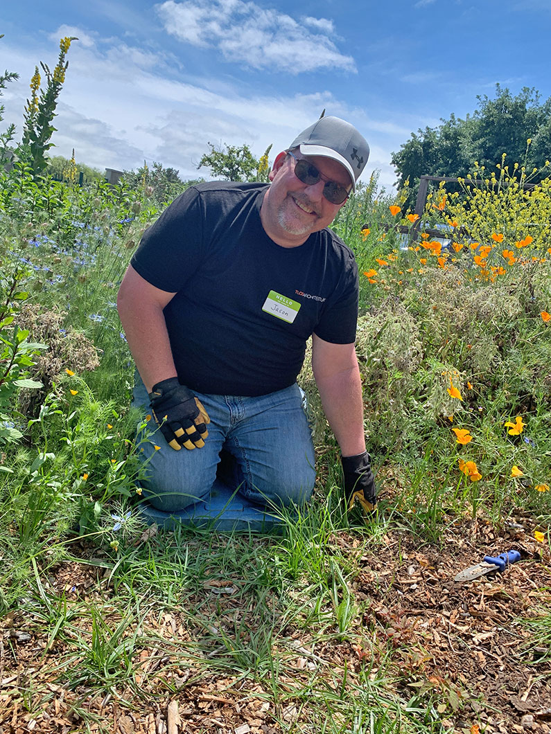 Man kneeling in garden while weeding