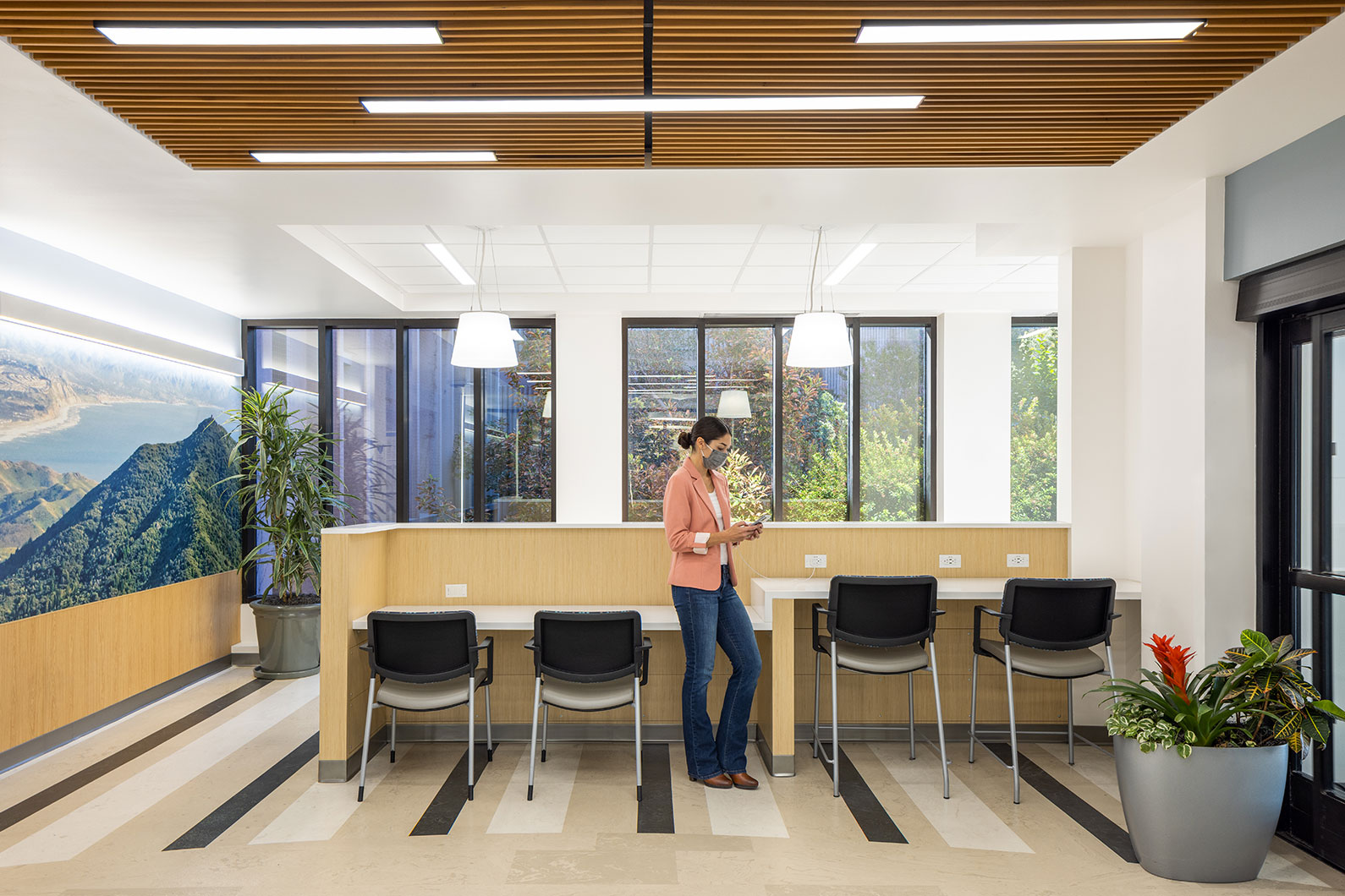 Woman standing next to recharge station in Kaiser San Rafael lobby