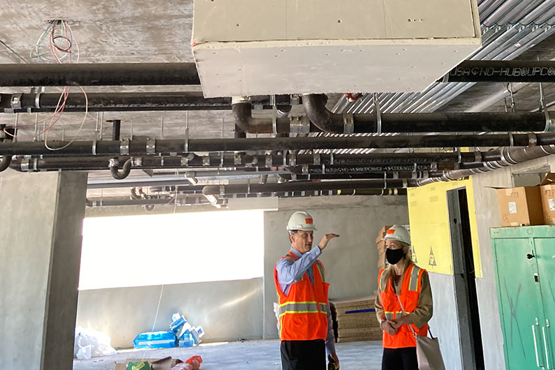 Kiely Rowe and David Delasantos touring building under construciton