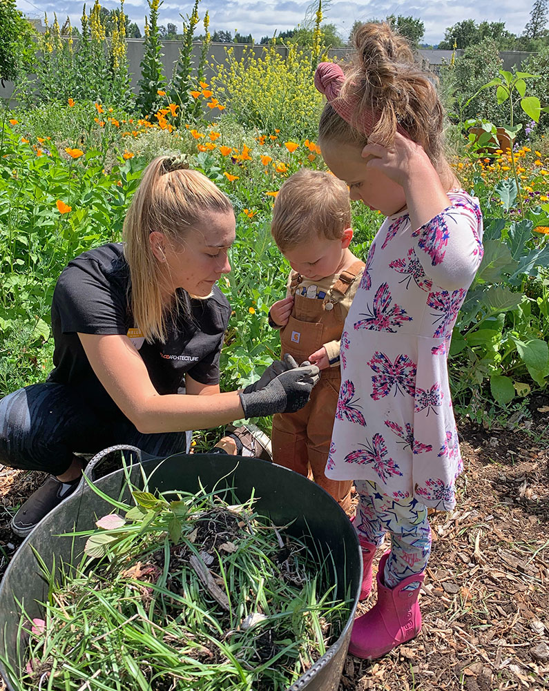 Kiely working in community garden with two young kids