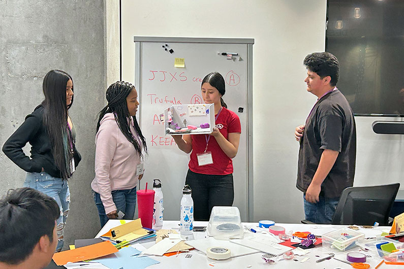 Group of middle school students presenting model making exercise at TLCD