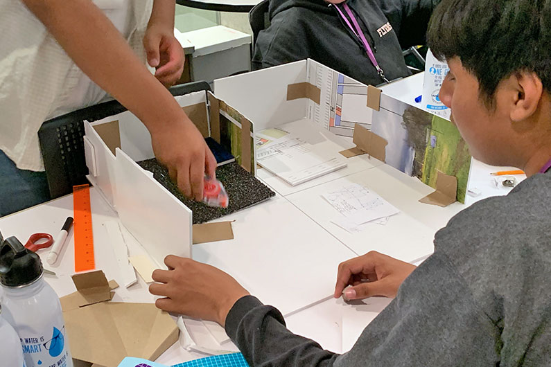 Group of middle school boys working on model for STEM project