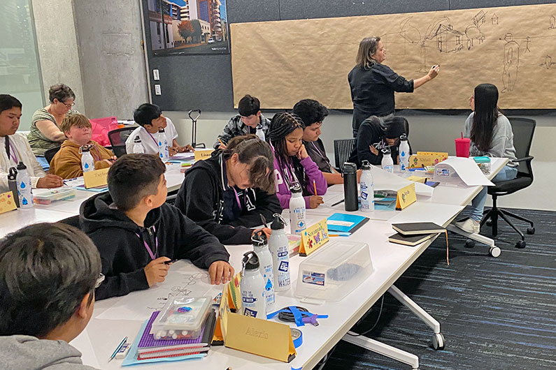 Architect showing kids how to sketch in TLCD Office