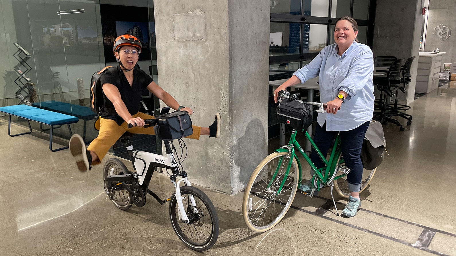 Two women on bikes in TLCD office for national bike to work day