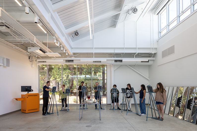 Students using easels to paint inside West Valley College Visual Arts Building