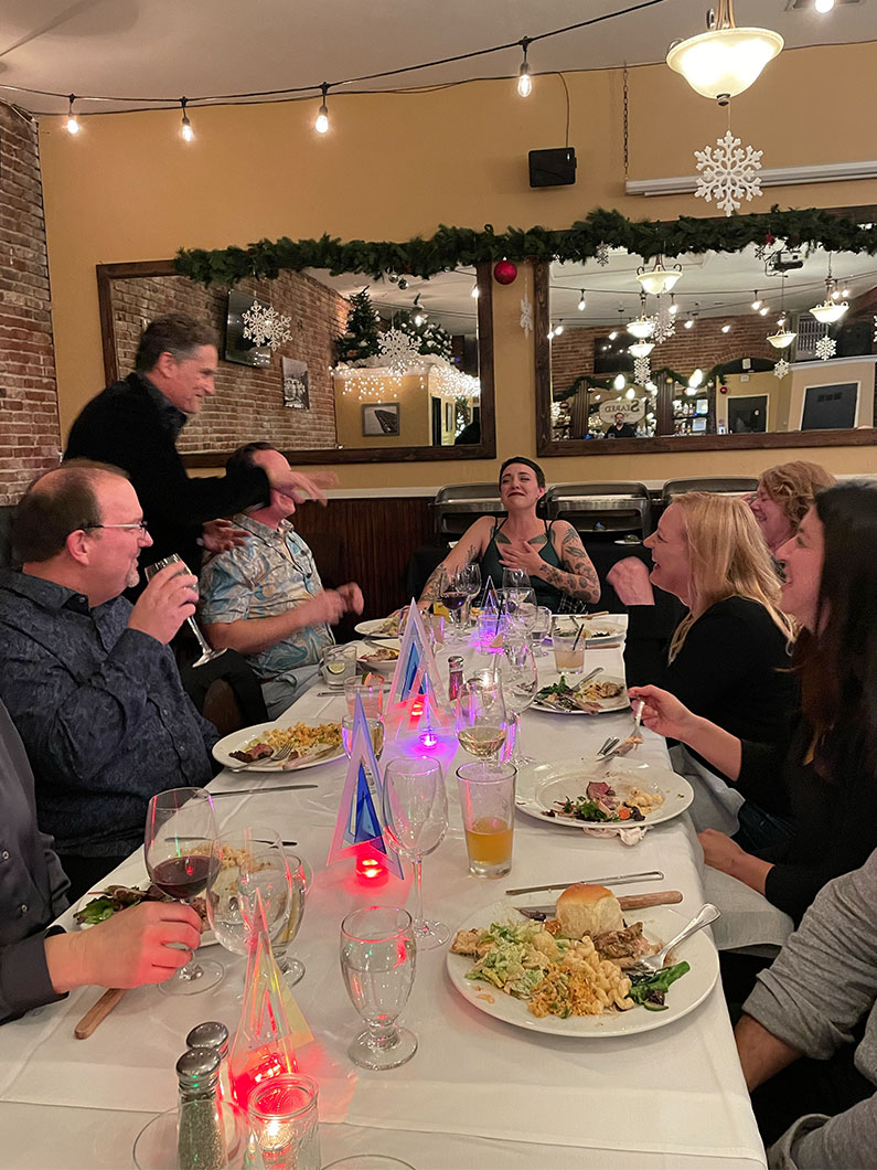 Large group at table laughing at a funny joke at TLCD's holiday party