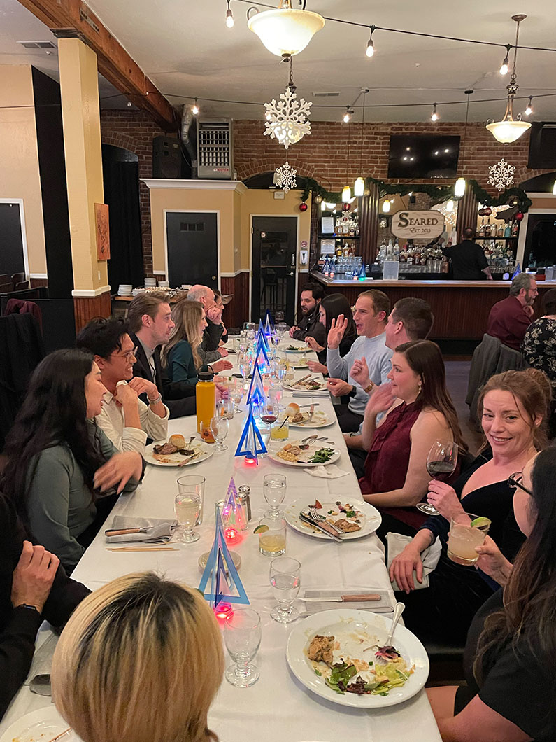 TLCD staff sitting at long table for holiday party