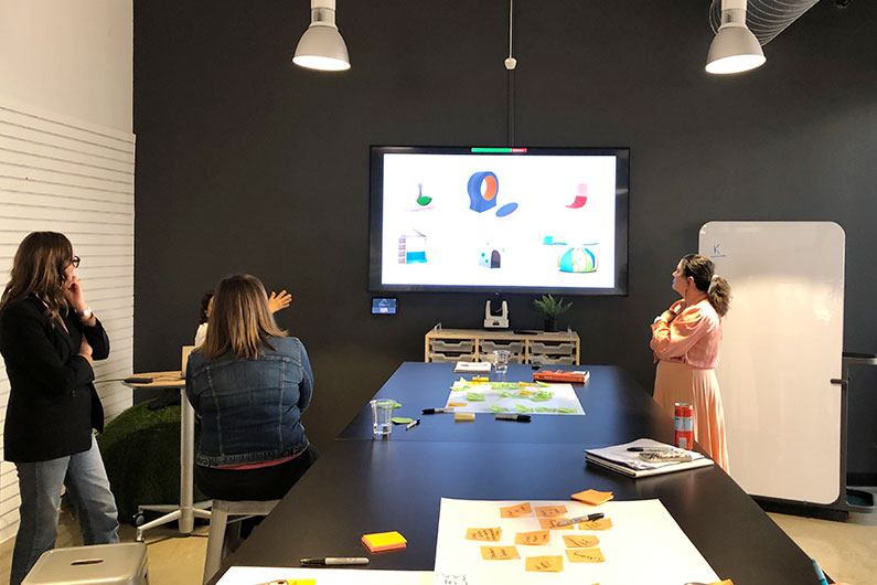 Group reviewing furniture options while brainstorming for prototype creation in front of computer screen