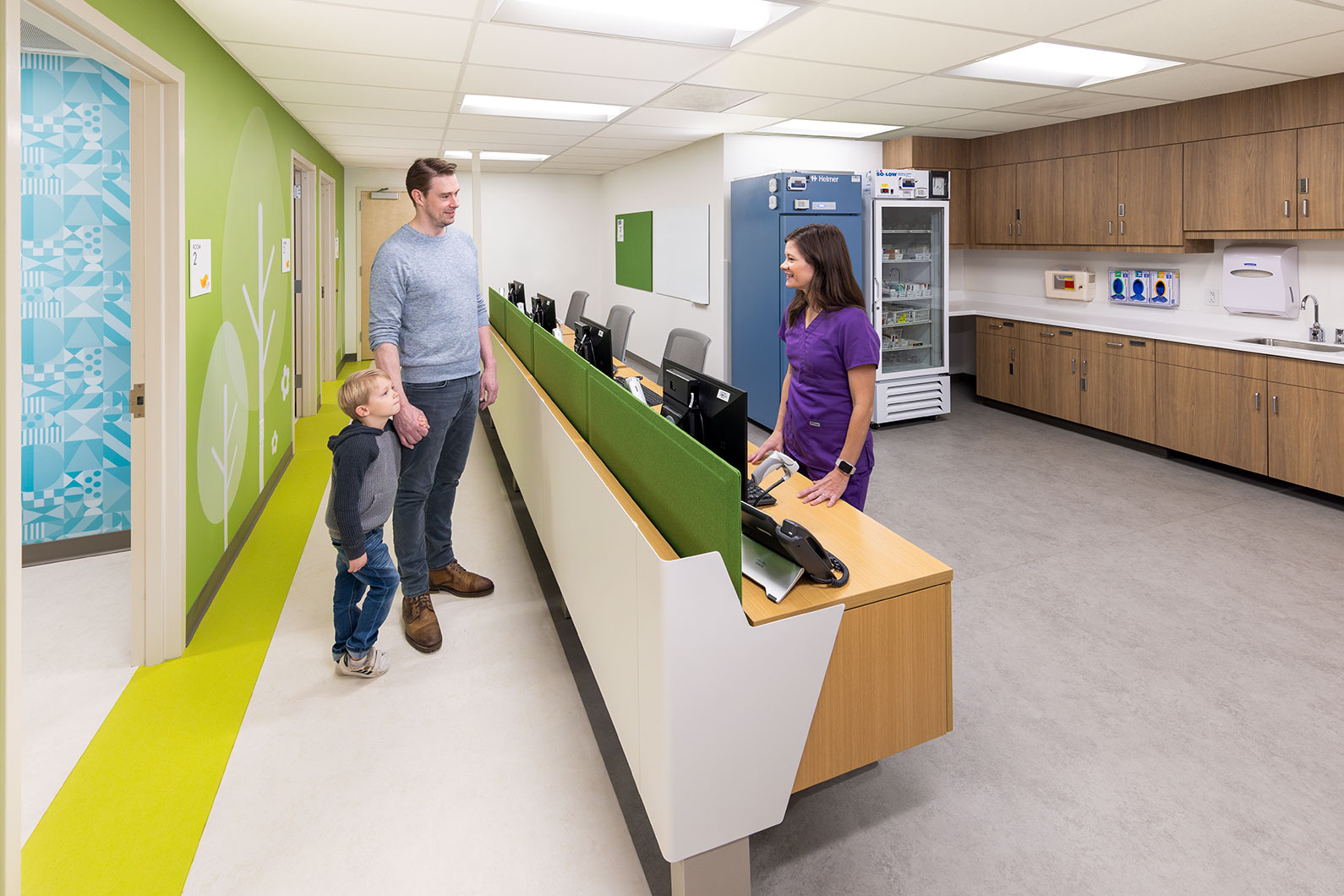 Father and son checking in with nurse in newly remodeled pediatric injection clinic