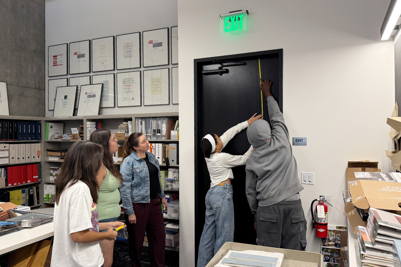 Group of students and TLCD team member measuring space for floor plan - Group photo of students gathered with teacher - Mike Hauser STEM Academy