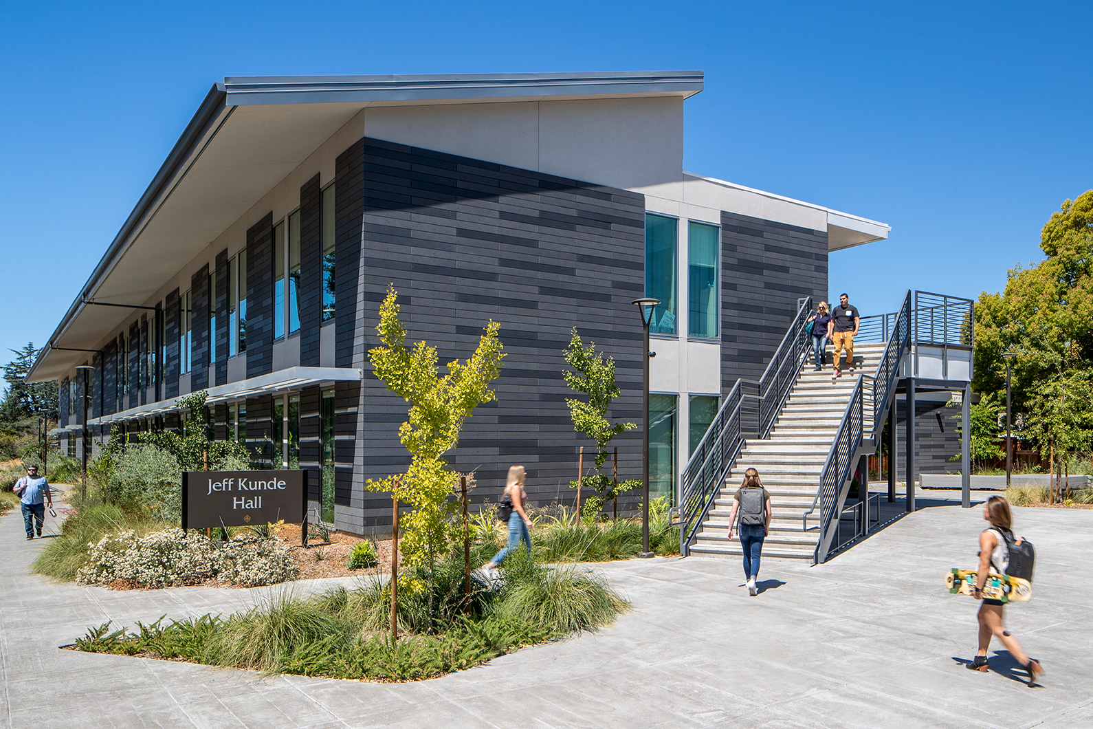 Exterior photo of Jeff Kunde Hal building with grand staircase and students walking by