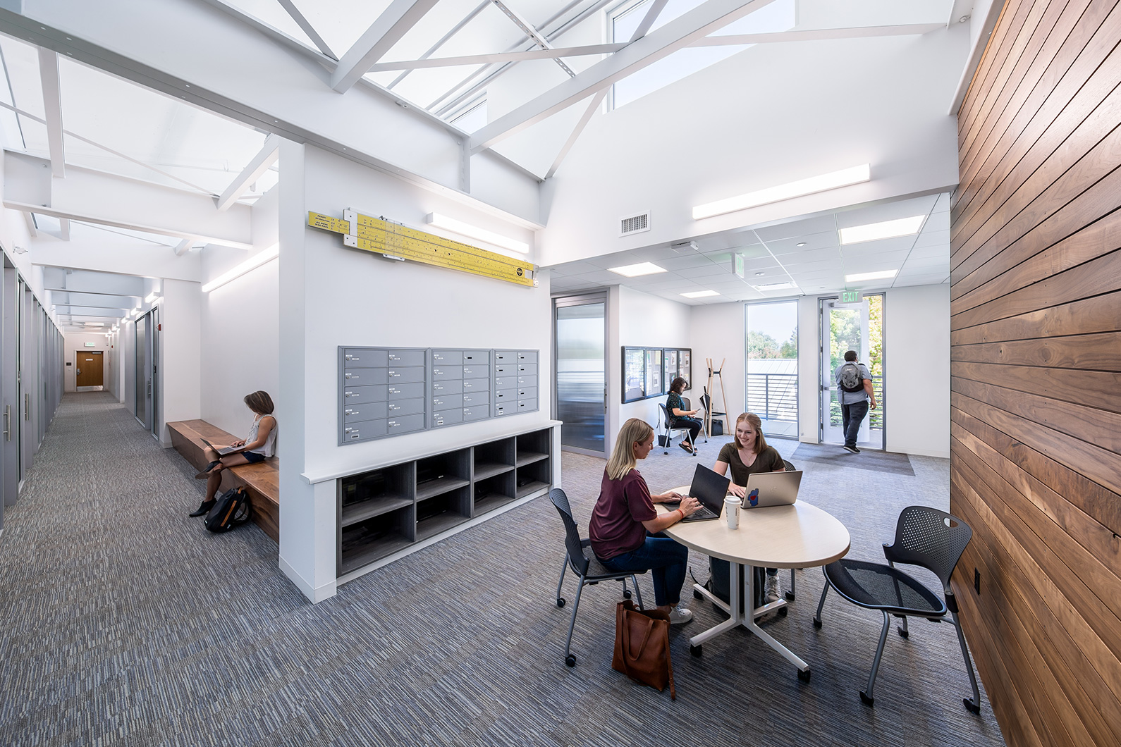 Interior photo of students meeting with instructors in upper level of Jeff Kunde Hall