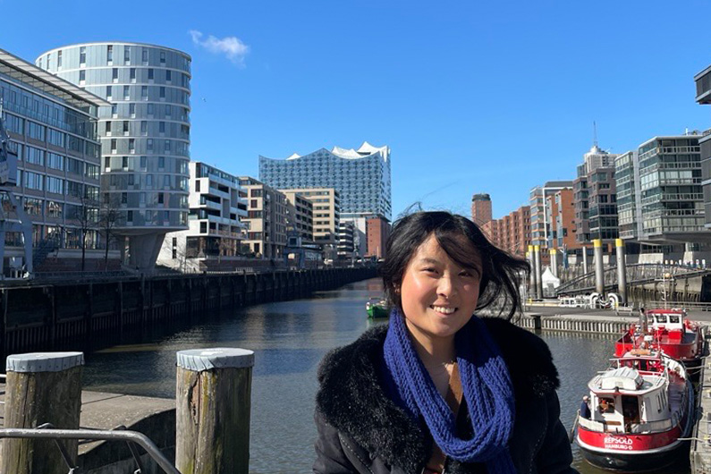Photo of Jessica in Europe with water, boats and buildings in background