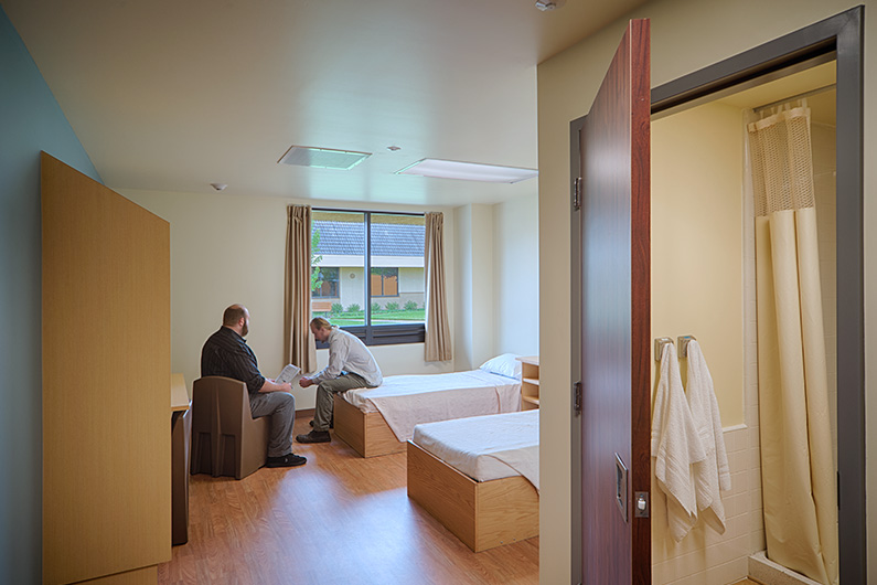 Counselor and patient sitting in bedroom at Aurora Behavioral Health in Santa Rosa