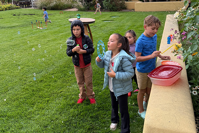 Kids blowing bubbles at TLCD summer picnic