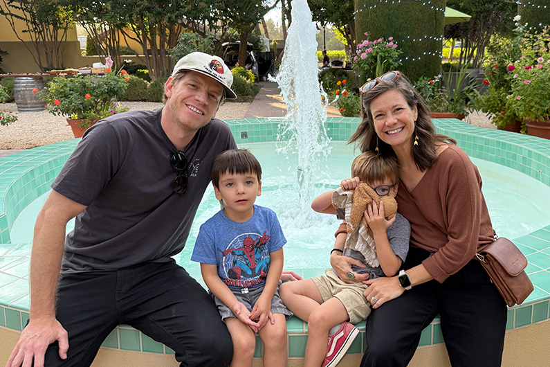 Family of 4 sitting on fountain at Landmark Vineyards