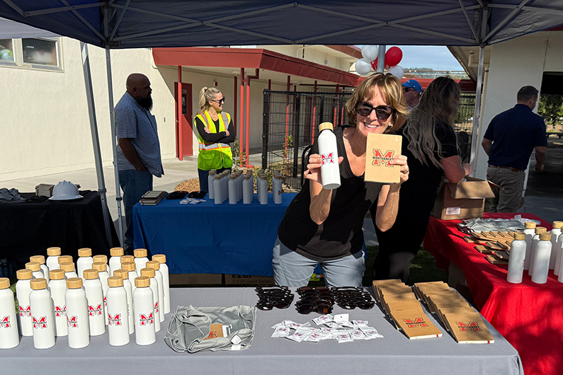 Marina Starkey at booth with swag for Montgomery High School Classroom building ribbon cutting