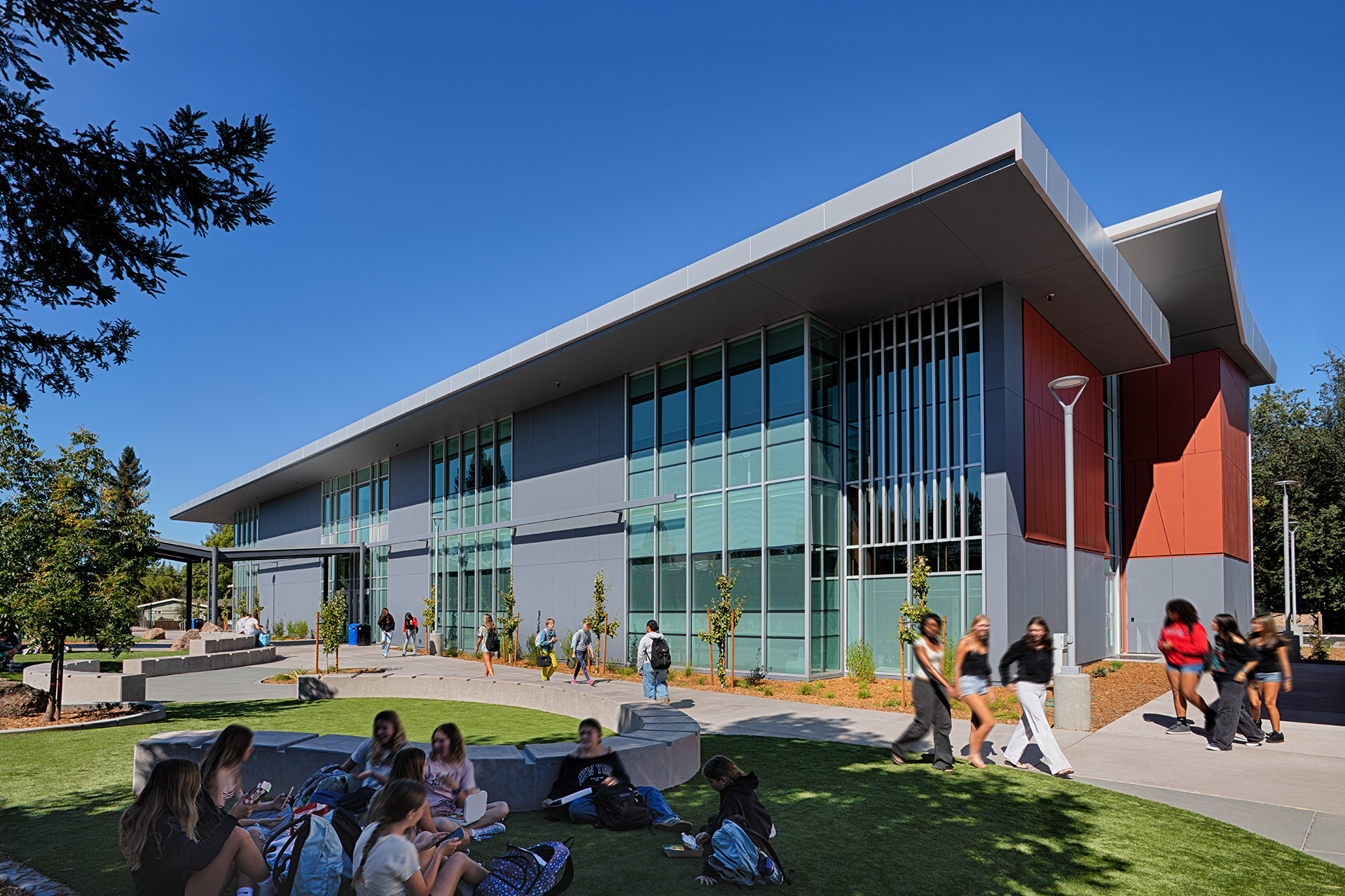 Exterior photo of Montgomery High School Classroom Building with students walking and hanging out in courtyard