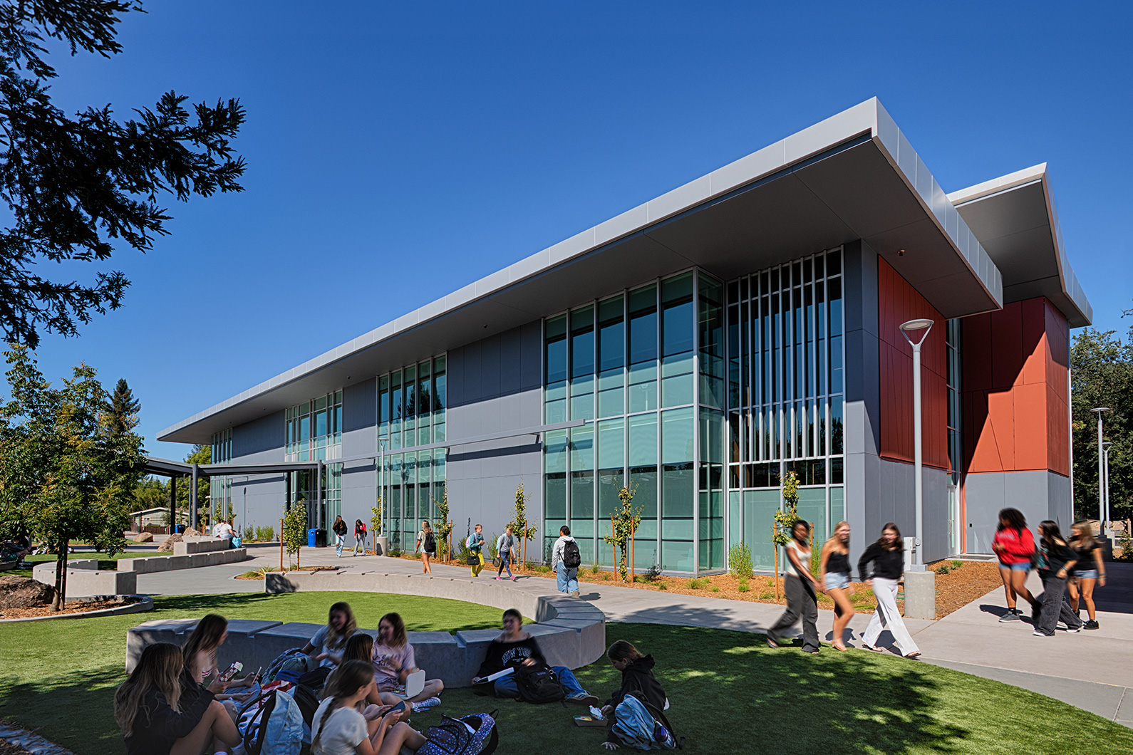Exterior photo of Montgomery High School Classroom Building with students walking and hanging out in courtyard
